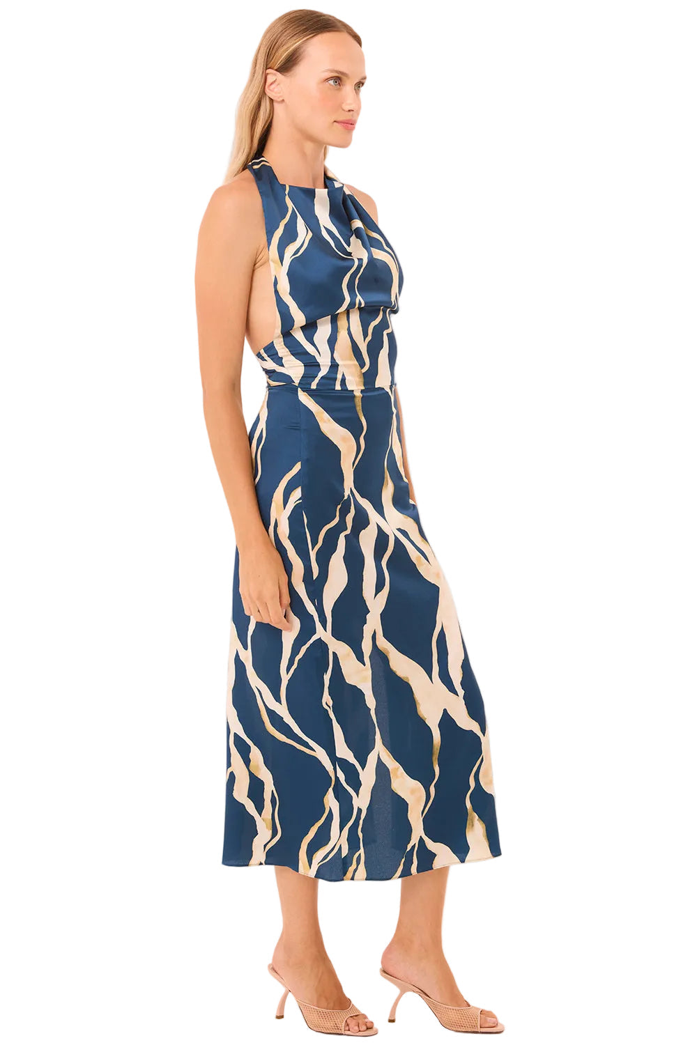 Woman wearing a blue and beige patterned dress on a beige background