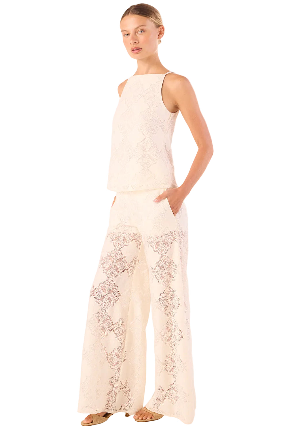 Woman wearing a white lace dress on a plain background