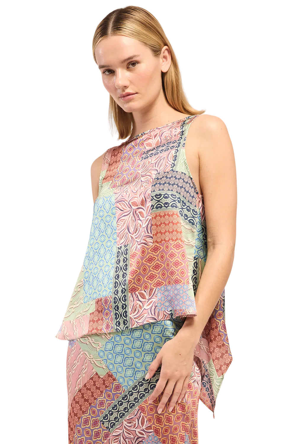 Woman wearing a colorful patterned sleeveless top on a light background